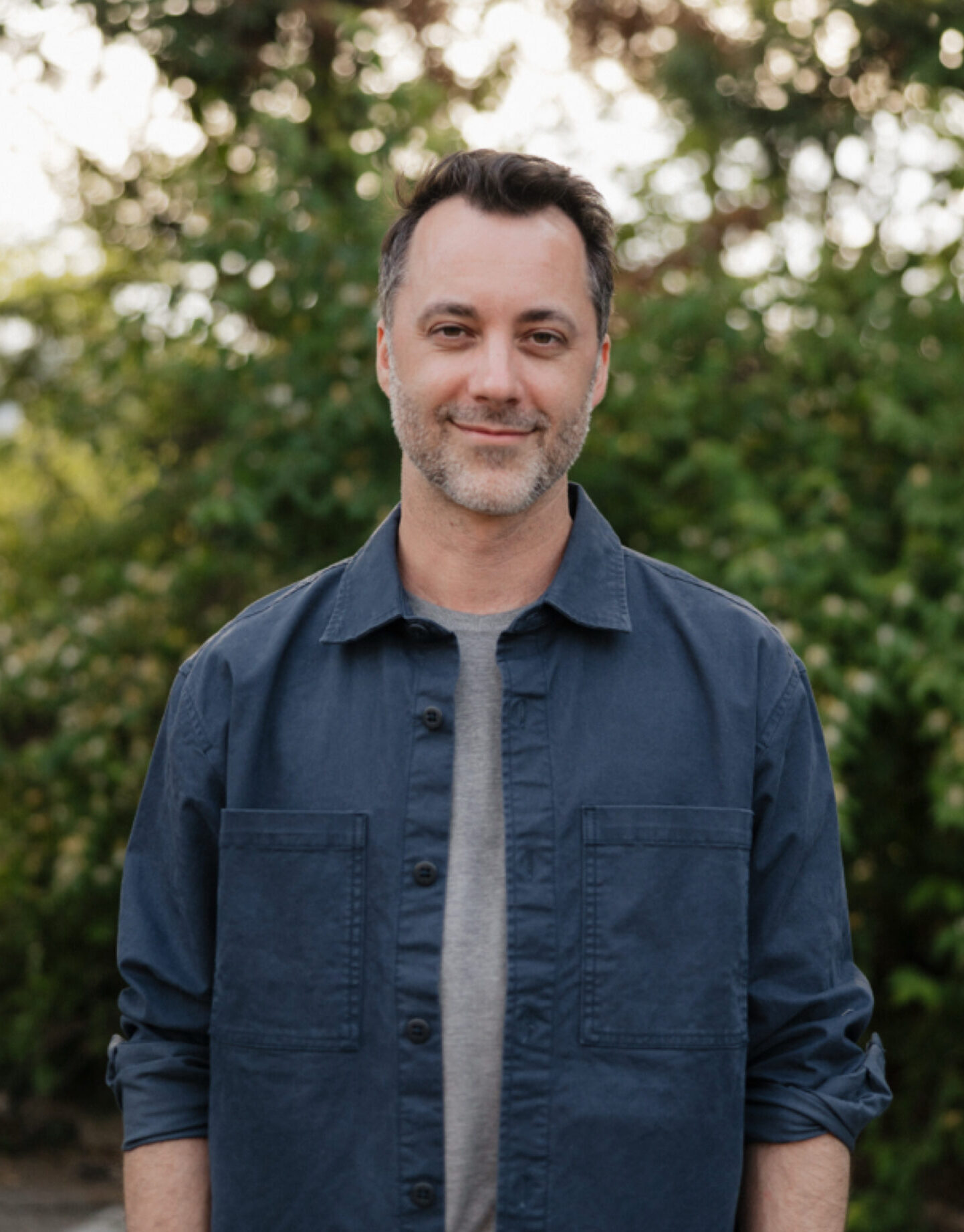 jason-pipkin-a-lpc-mhsp-therapist-nashville-tn Jason Pipkin, A-LPC/MHSP, therapist in Nashville, Tennessee, standing outdoors with a green natural background.