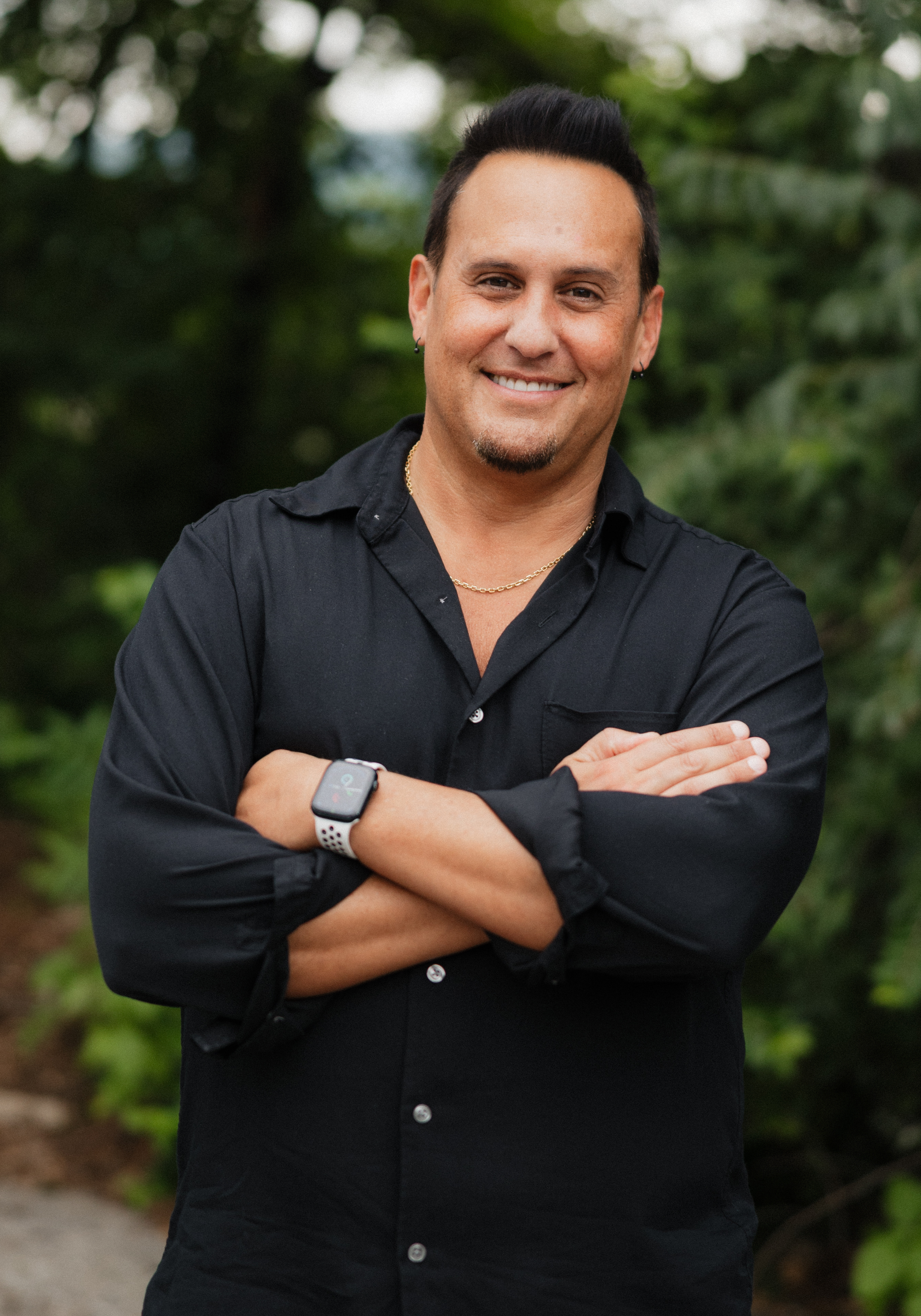 Cadey Phipps, LMFT, therapist in Nashville, Tennessee, seated outdoors and smiling, with a green natural background.