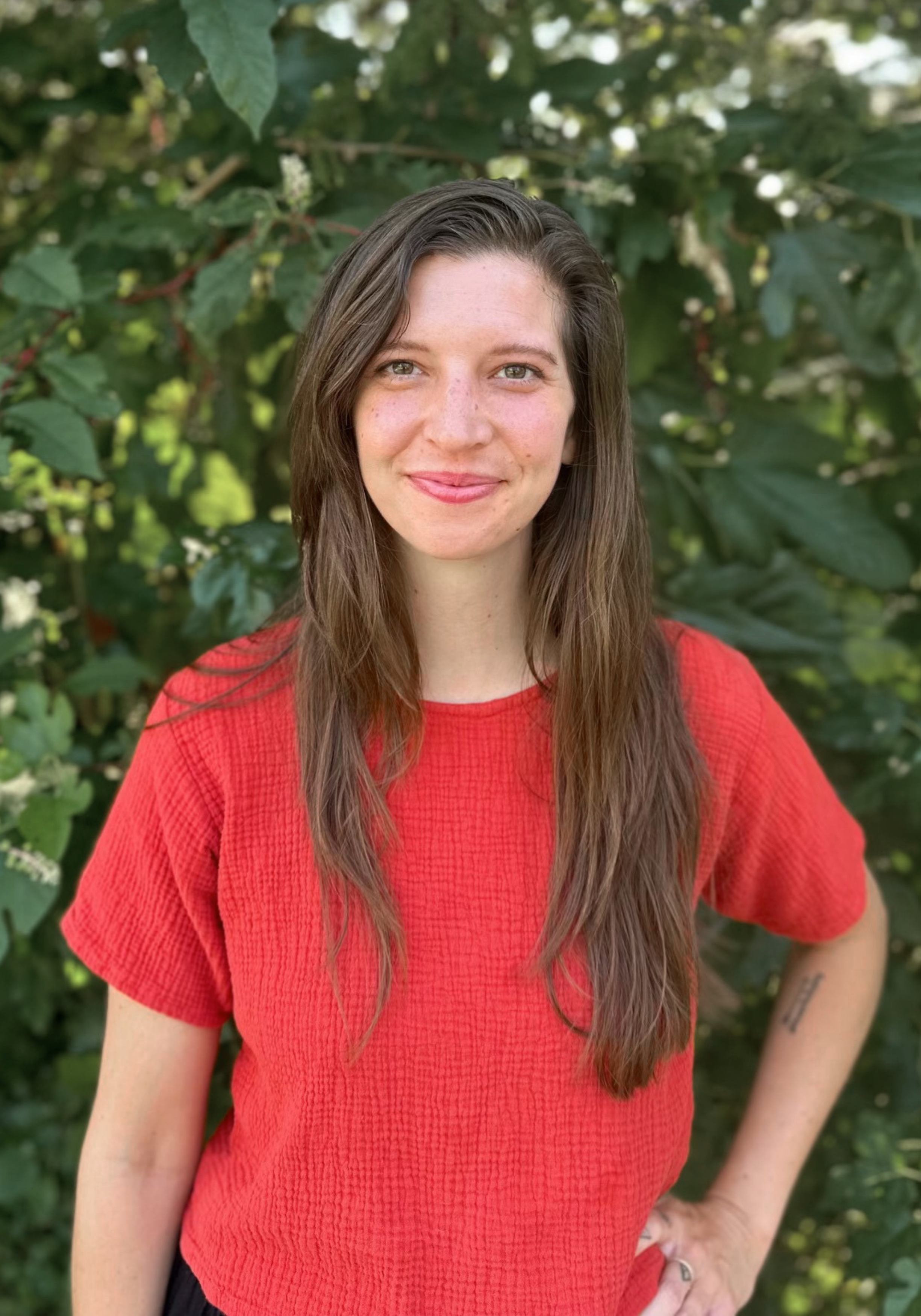jenna-sanders-alpc-mhsp-nashville-therapist Cadey Phipps, LMFT, therapist in Nashville, Tennessee, seated outdoors and smiling, with a green natural background.