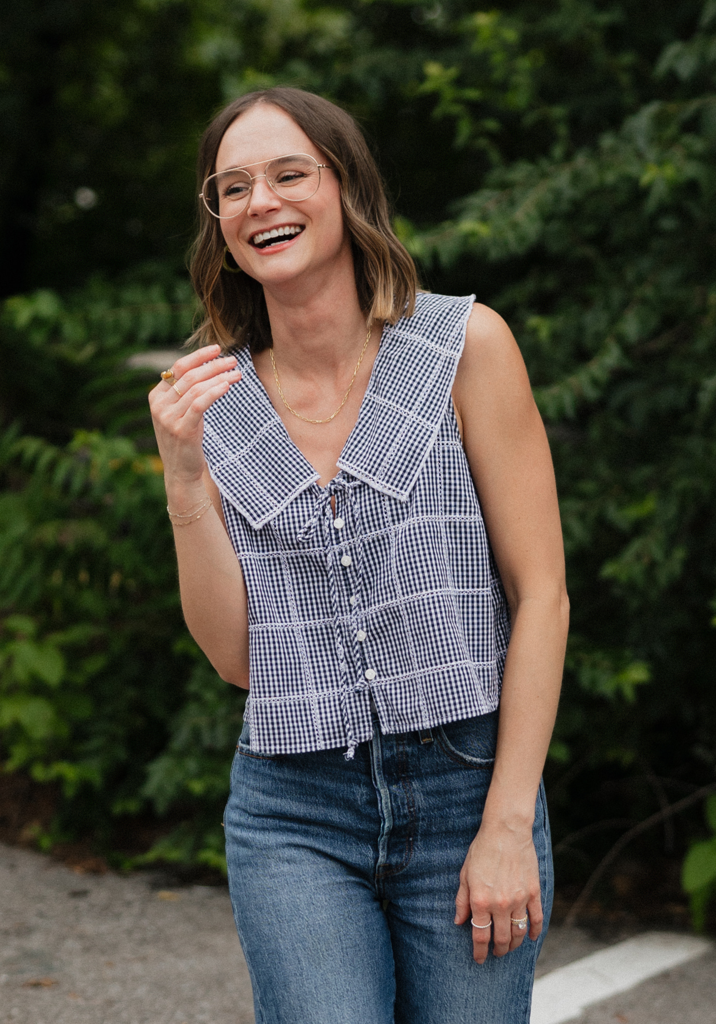 sydney-brayer-alpc-mhsp-nashville-therapist Cadey Phipps, LMFT, therapist in Nashville, Tennessee, seated outdoors and smiling, with a green natural background.